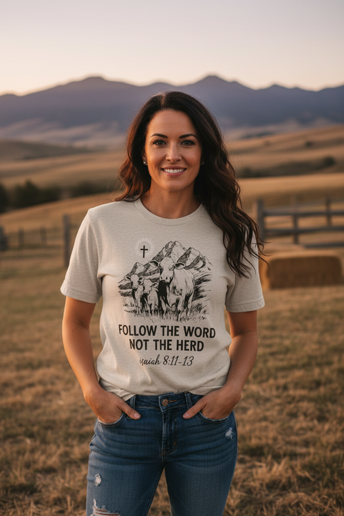 Woman wearing a t-shirt with a motivational quote in a field with mountains in the background
