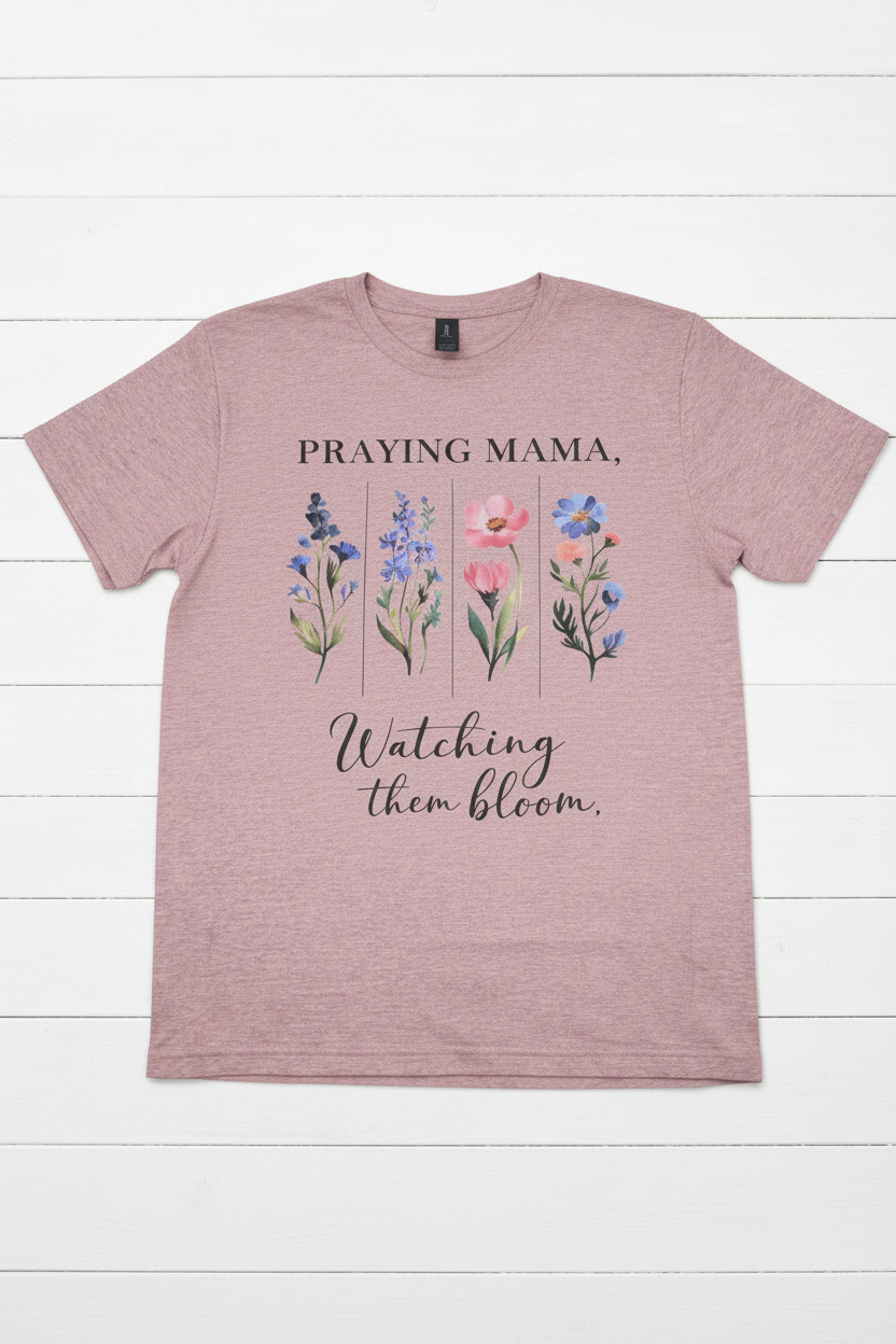 "Praying Mama Watching Them Bloom Christian t-shirt in Plumrose — watercolor wildflower graphic by Pressed in Faith by Anna"